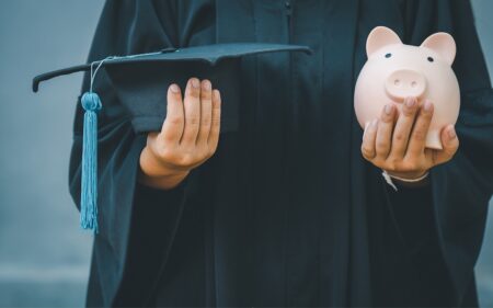 Scholarships Now Open for Meeker Energy Members 1 graduate holding cap and piggy bank for a scholarship