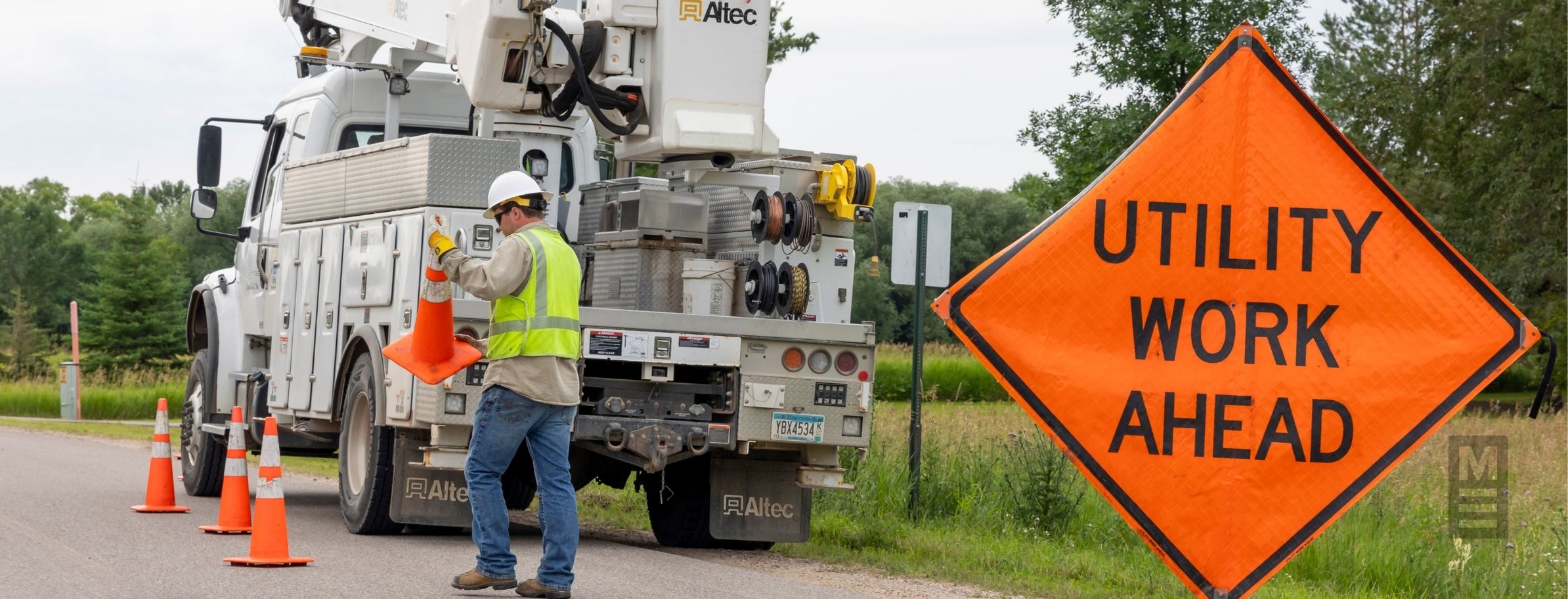 setting up utility work ahead sign and orange traffic cones