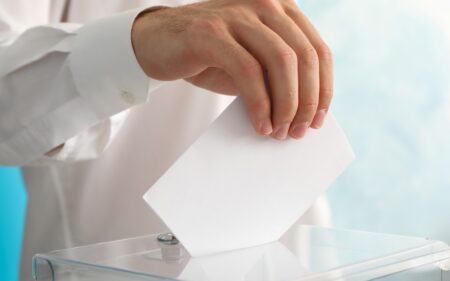 voting ballot going into the box